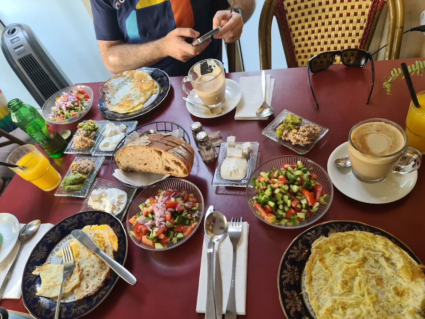 Café Meshulash breakfast table with eggs, salads, bread and cappuccinos